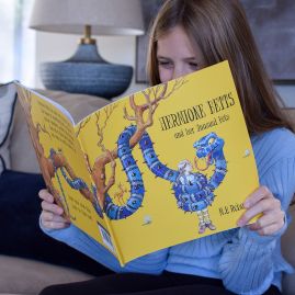 A young girl immersed in reading a book.