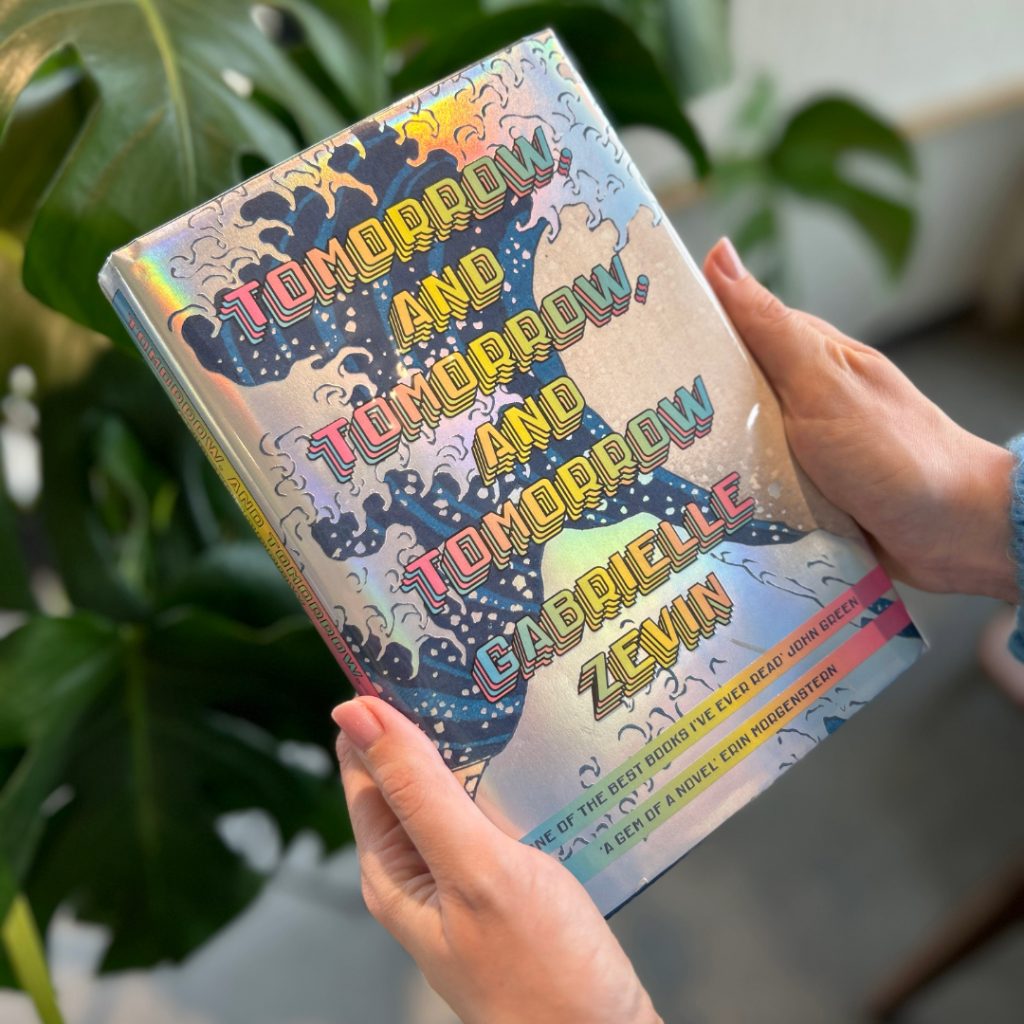 Jess holding her top reads of 2024 - Tomorrow and Tomorrow and Tomorrow