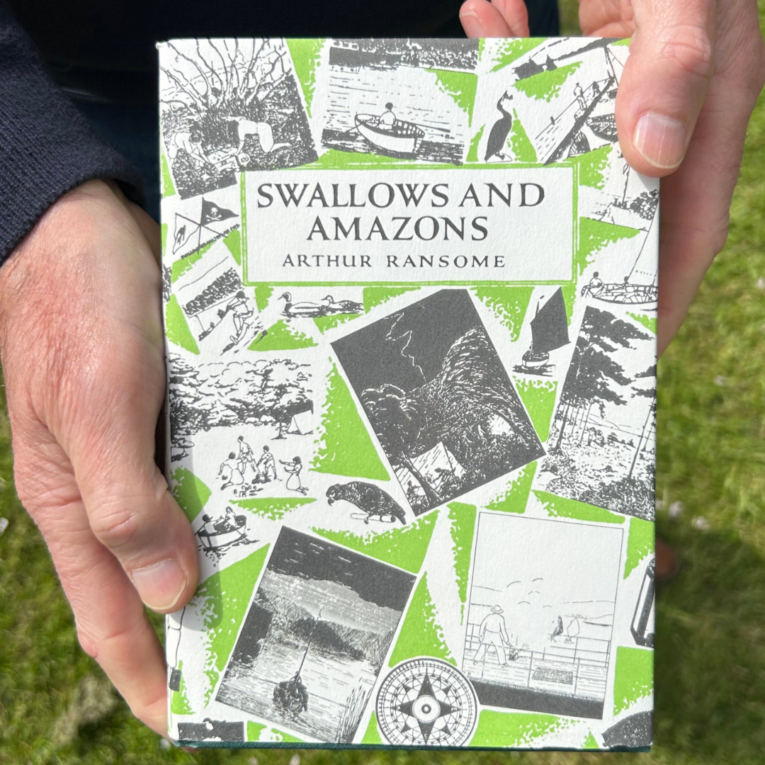 Neil holding his top reads of 2024 - Swallows and Amazons book