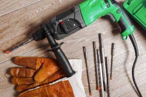 green drill laid out on wooden floor